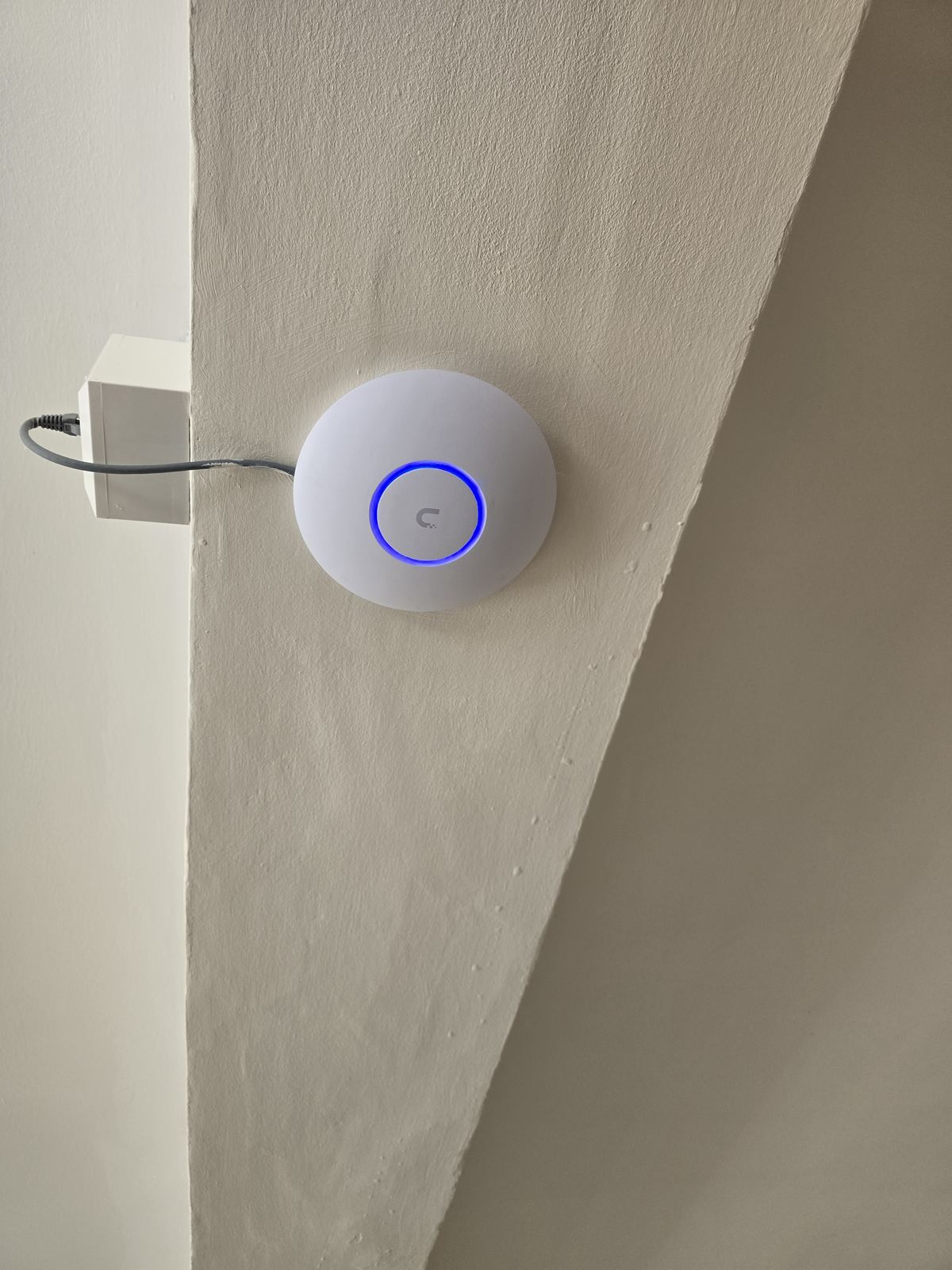 Ceiling-mounted Wi-Fi access point installed on a landing in a Stockport home