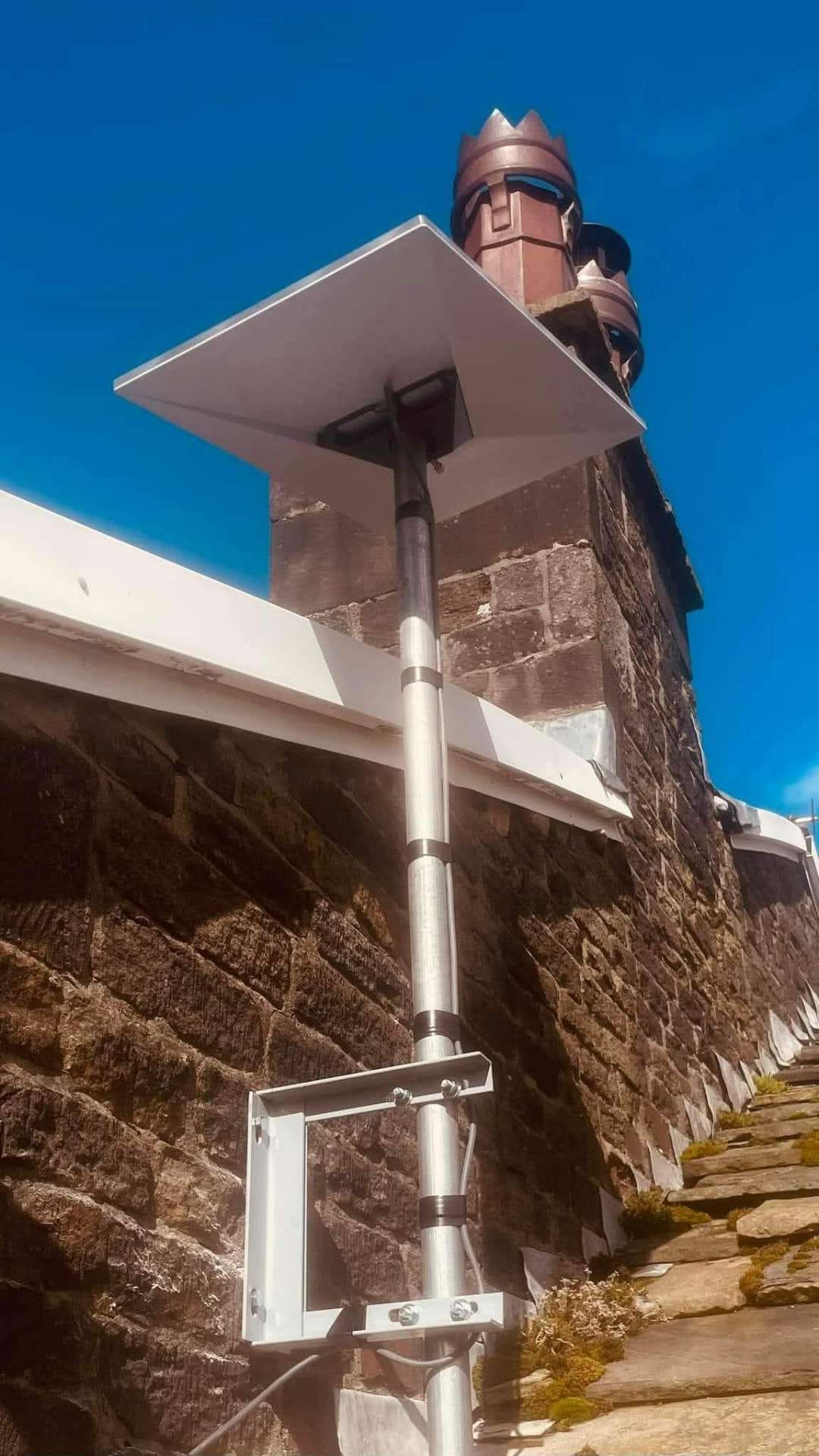 Starlink dish installed on a chimney with weather-sealed cabling