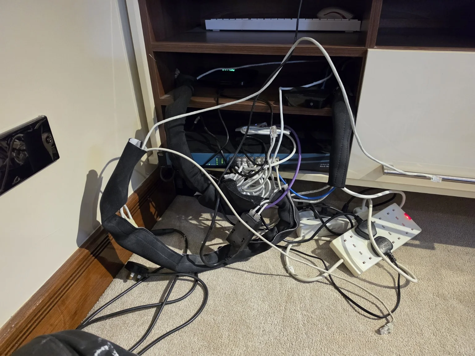 Home network equipment with loose patch leads and multiple power adapters before the Cheadle UniFi rebuild