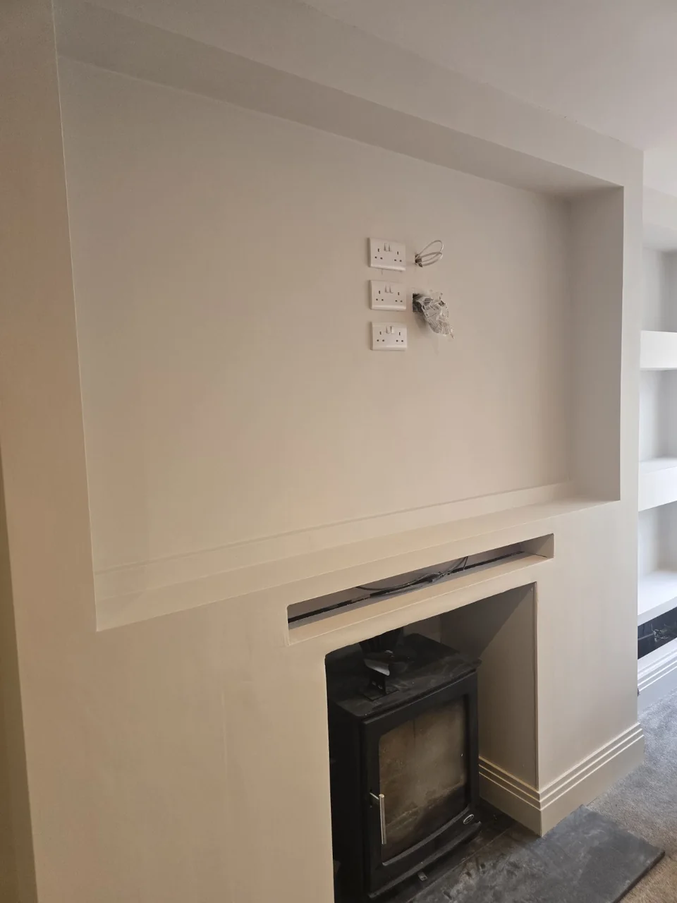 Prestwich media wall before TV mounting showing the prepared connection points behind the screen position
