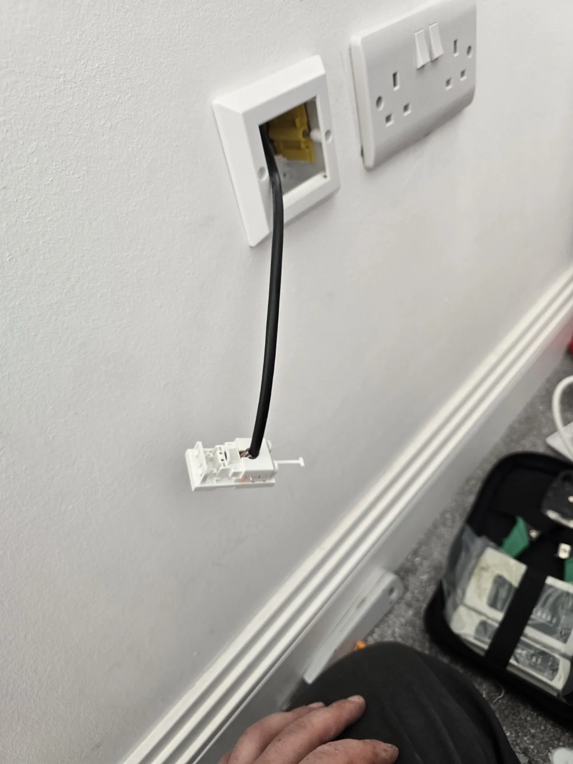 Network cable emerging at an existing wall outlet during the Clock Face Ethernet retrofit