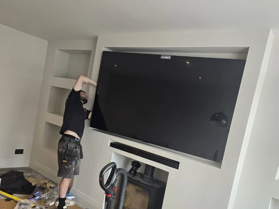 Large OLED television mounted into a media wall in Prestwich during a combined TV and Wi-Fi upgrade