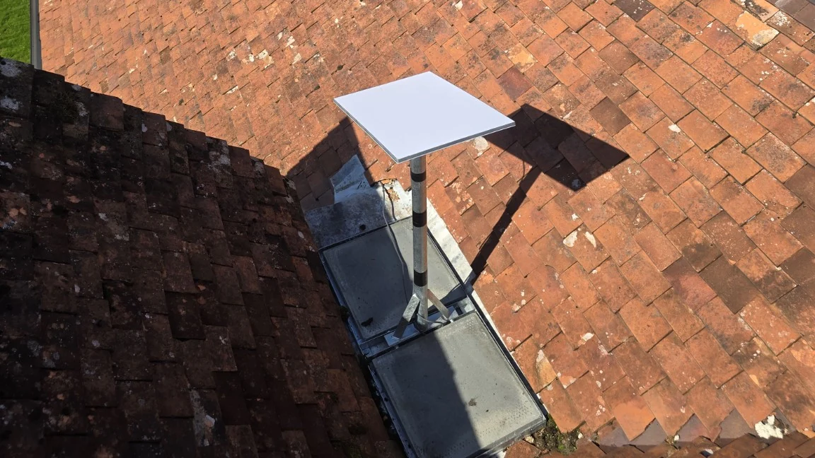 Starlink dish on a weighted frame within a tiled roof valley at a home in Alderley Edge, Cheshire