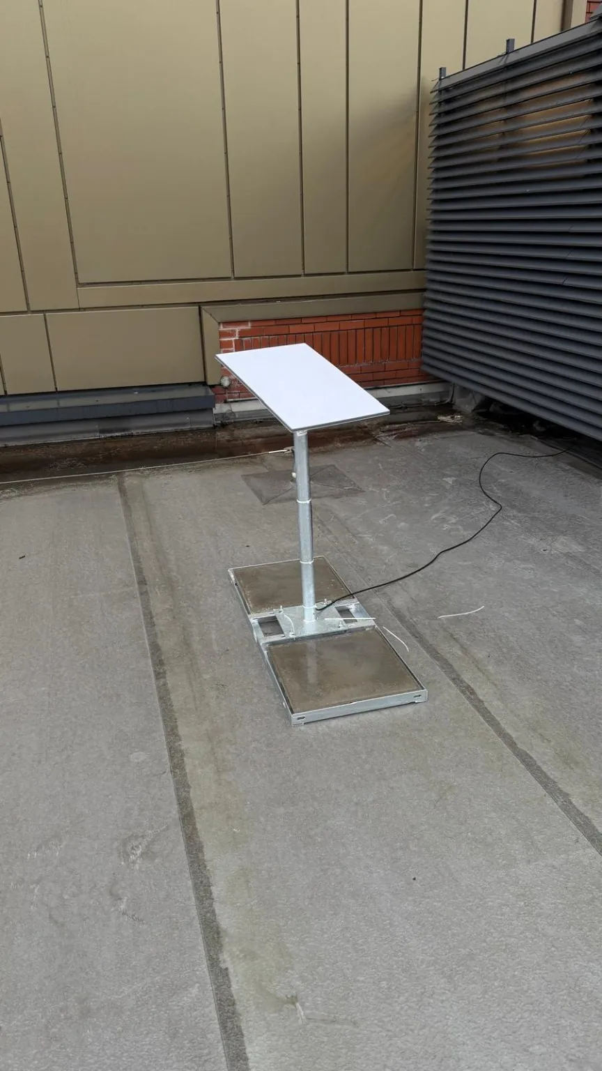 Commercial Starlink installation on a concrete-weighted non-penetrating roof mount in Manchester city centre