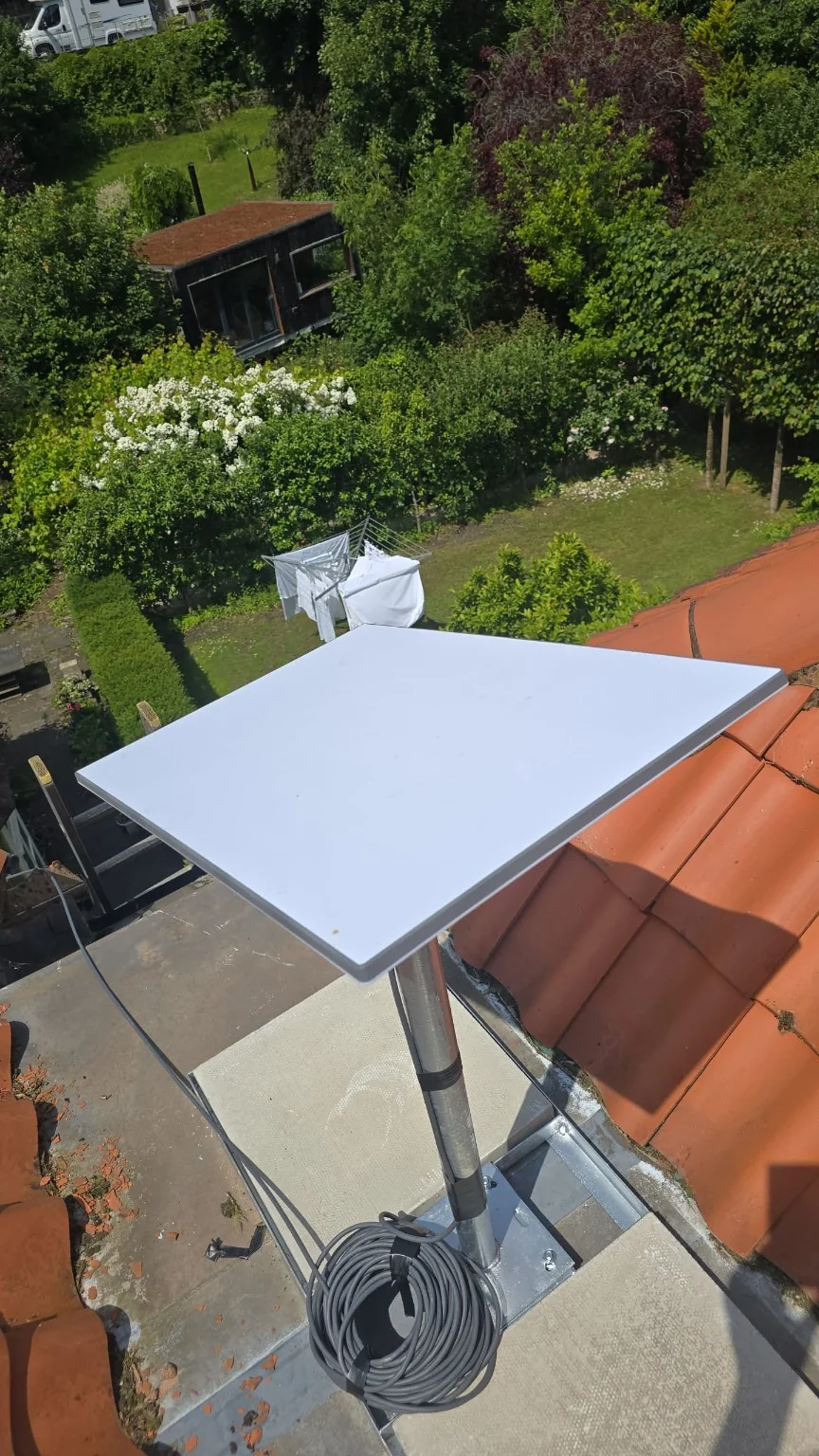 Close view of the customer-supplied Starlink dish, mast and concrete flagstones on the non-penetrating mount