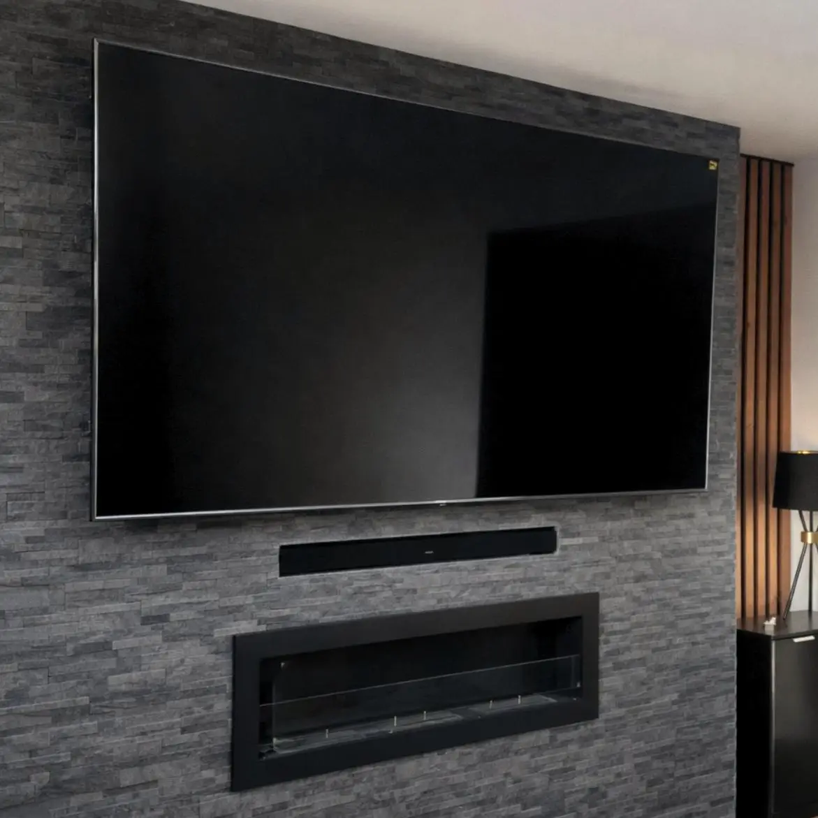 Professional TV wall mount installation in Stockport with soundbar and media wall